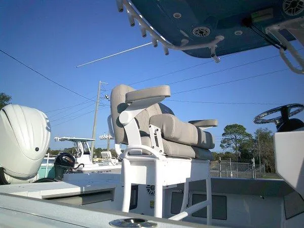 Slide: The Image of 2025 Sportsman 247 MASTERS boat interior with seating and steering wheel under clear blue sky. - 11