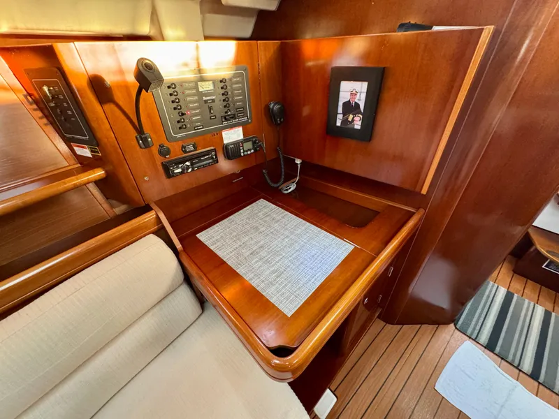 Slide: The Image of Navigation station in 2006 Beneteau Oceanis Clipper 343 yacht, featuring control panel and wooden finish. - 11