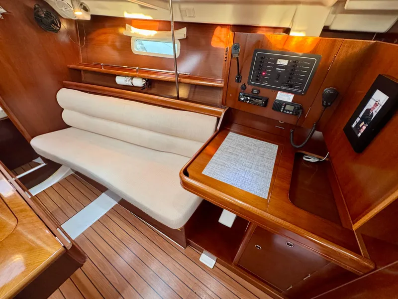 Slide: The Image of Interior of 2006 Beneteau Oceanis Clipper 343, featuring wood finish and navigation panel. - 12