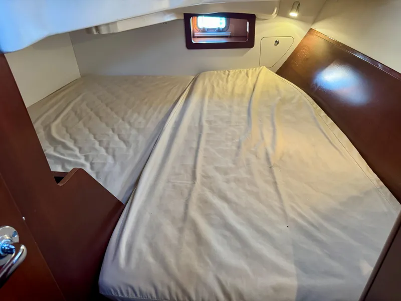 Slide: The Image of 2006 Beneteau Oceanis Clipper 343 cabin with cozy bed and wooden interior. - 19