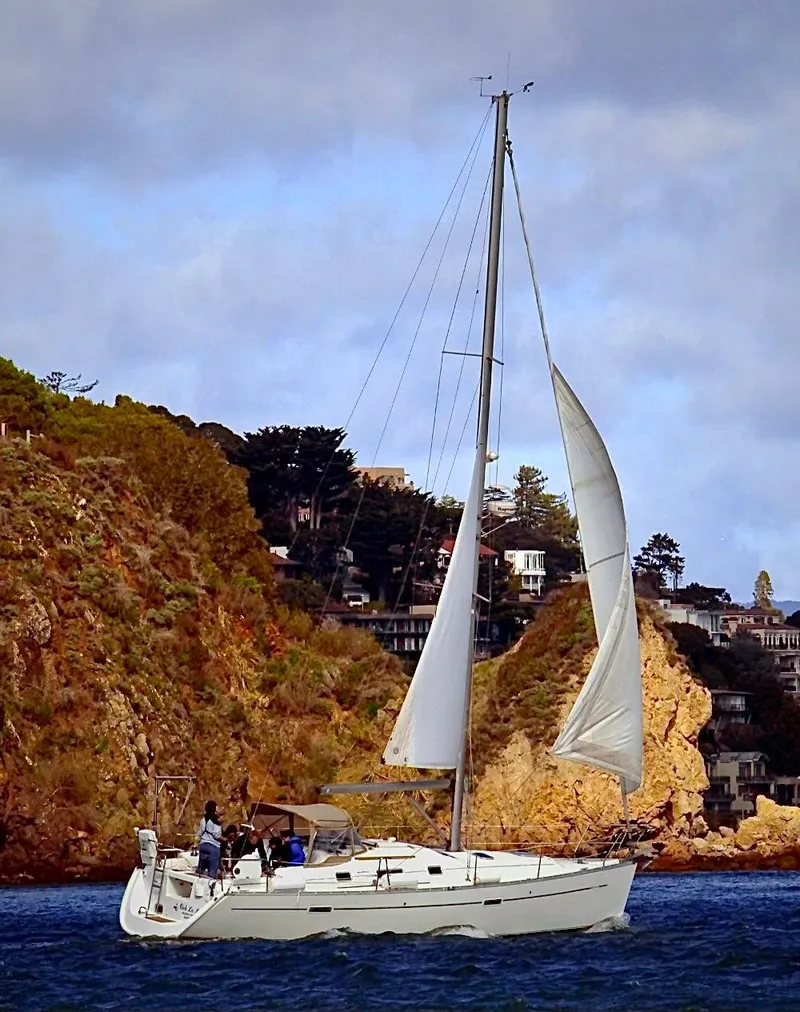 Slide: The Image of 2006 Beneteau Oceanis Clipper 343 sailing near rocky coastline under cloudy sky. - 2