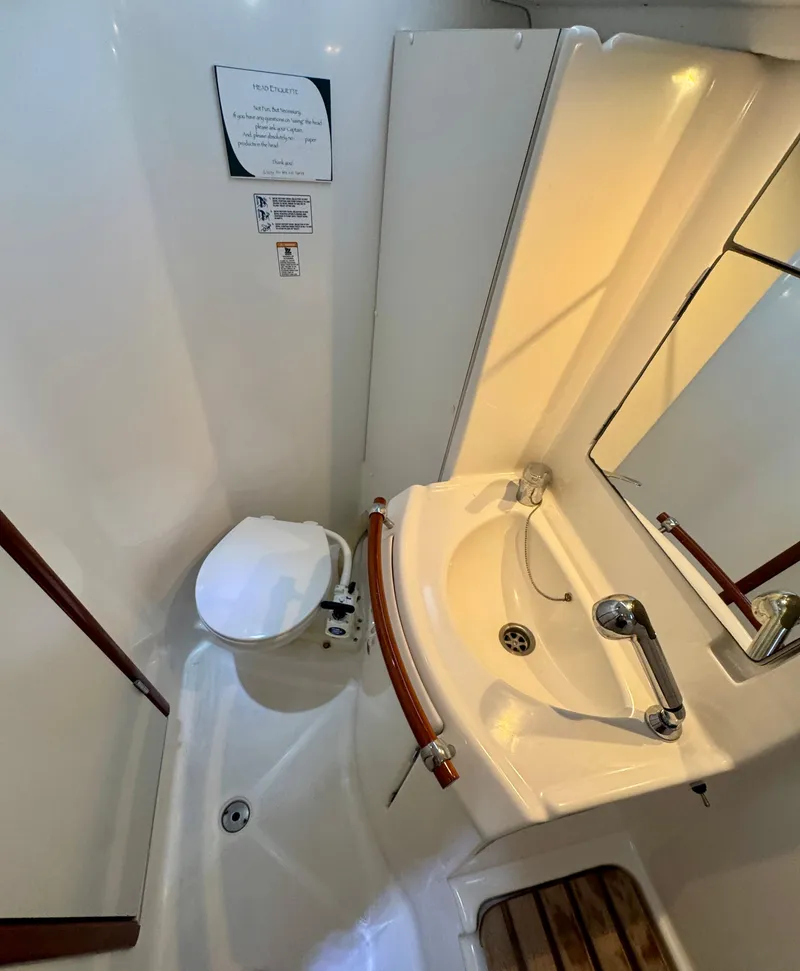 Slide: The Image of 2006 Beneteau Oceanis Clipper 343 bathroom with toilet, sink, and shower area. - 21