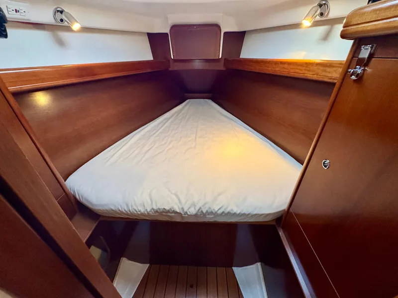 Slide: The Image of Beneteau Oceanis Clipper 343 (2006) cabin interior with wooden finish and cozy bed. - 23