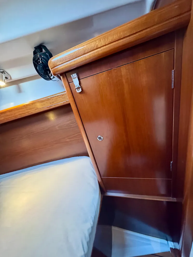 Slide: The Image of Interior cabin of 2006 Beneteau Oceanis Clipper 343, featuring wooden cabinetry and bedding. - 25