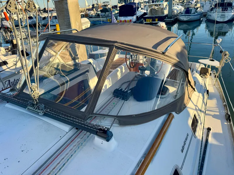 Slide: The Image of 2006 Beneteau Oceanis Clipper 343 sailboat docked in a marina, featuring a covered cockpit. - 5