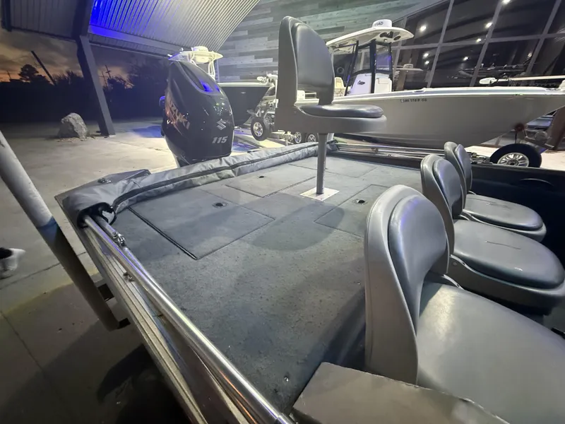 Slide: The Image of 1998 SeaArk ZX180 boat interior with seating and motor, displayed indoors. - 11