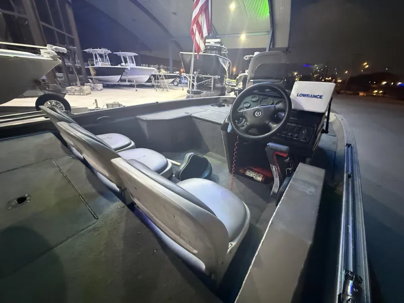 Slide: The Image of 1998 SeaArk ZX180 boat interior with steering wheel and Lowrance device, docked at night. - 12