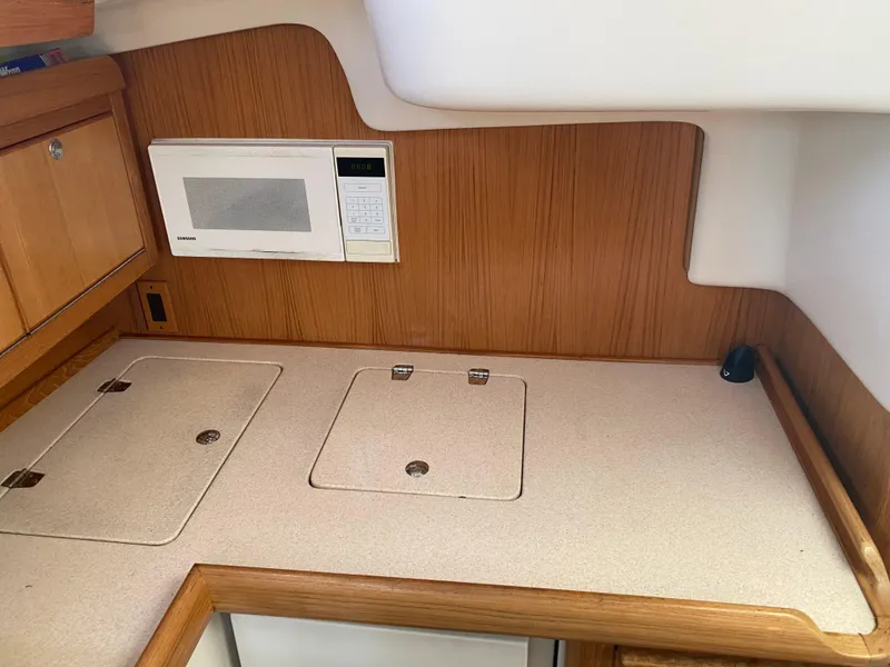 Slide: The Image of Galley of 2003 Catalina 350 sailboat with microwave and storage compartments. - 15