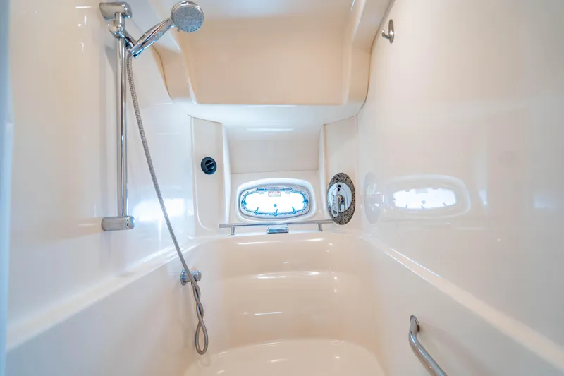 Slide: The Image of 2005 Sea Ray 48 Sundancer cruising on open water with city skyline in background. - 11