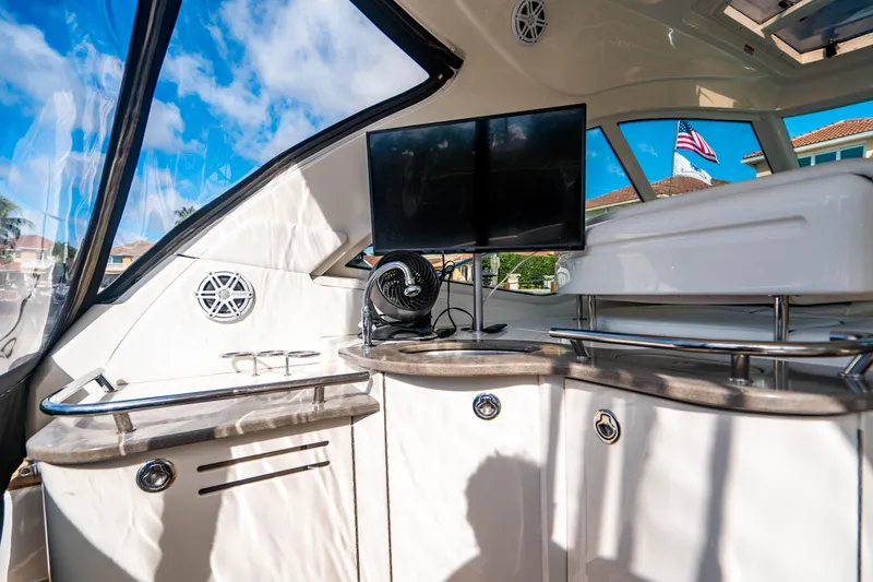 Slide: The Image of 2005 Sea Ray 48 Sundancer cruising on open water with bridge in background. - 17