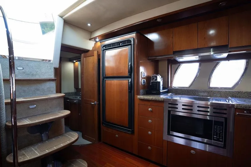 Slide: The Image of Luxurious 2005 Sea Ray 48 Sundancer yacht interior with modern kitchen and wooden cabinetry. - 27
