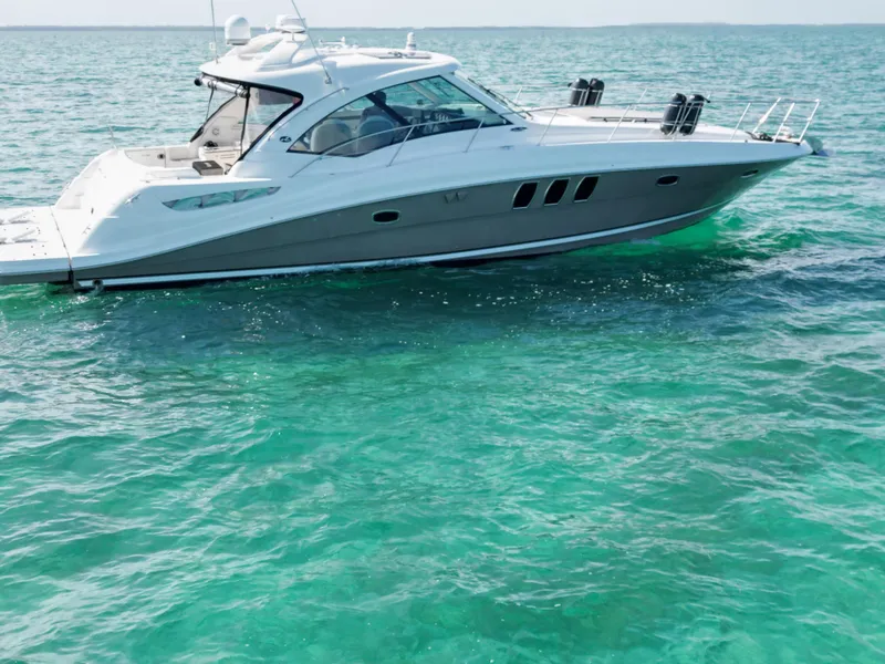 Slide: The Image of 2005 Sea Ray 48 Sundancer cruising on open water under a clear blue sky. - 3