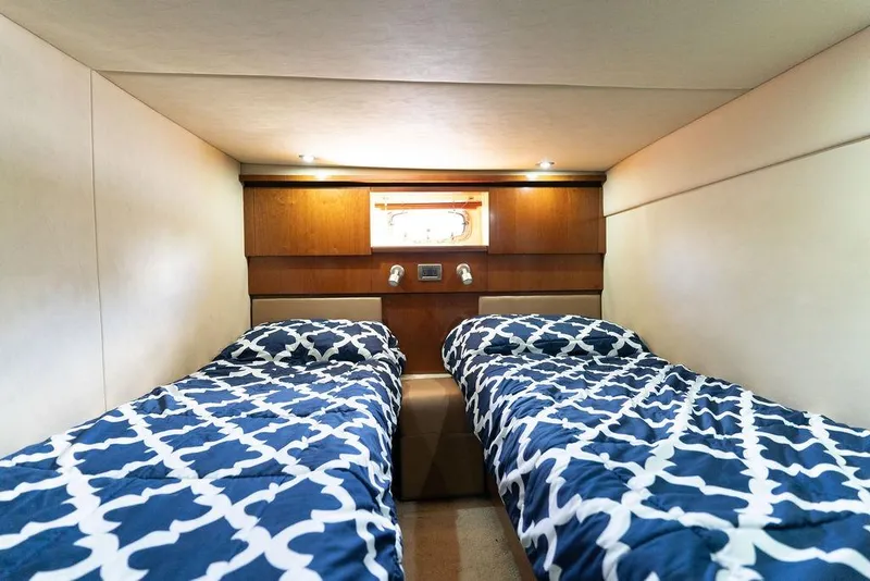 Slide: The Image of Twin beds in 2005 Sea Ray 48 Sundancer cabin with patterned blue bedding. - 31
