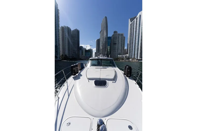 Slide: The Image of 2005 Sea Ray 48 Sundancer yacht cruising near city skyscrapers under clear blue sky. - 45
