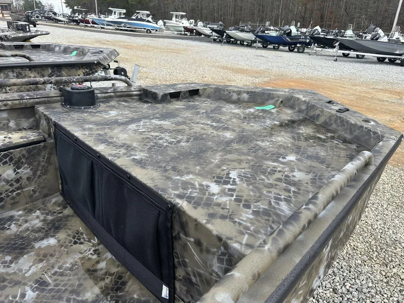 Slide: The Image of 2025 Excel Shallow Water F4 boat with camouflage design, displayed in a gravel lot. - 3