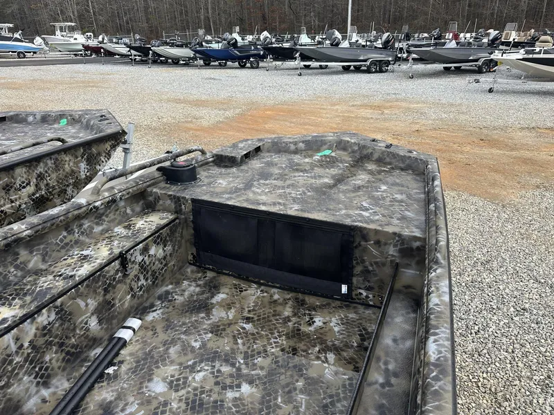 Slide: The Image of 2025 Excel Shallow Water F4 1754 F86 HDR5000 boat in a gravel lot with other boats. - 4