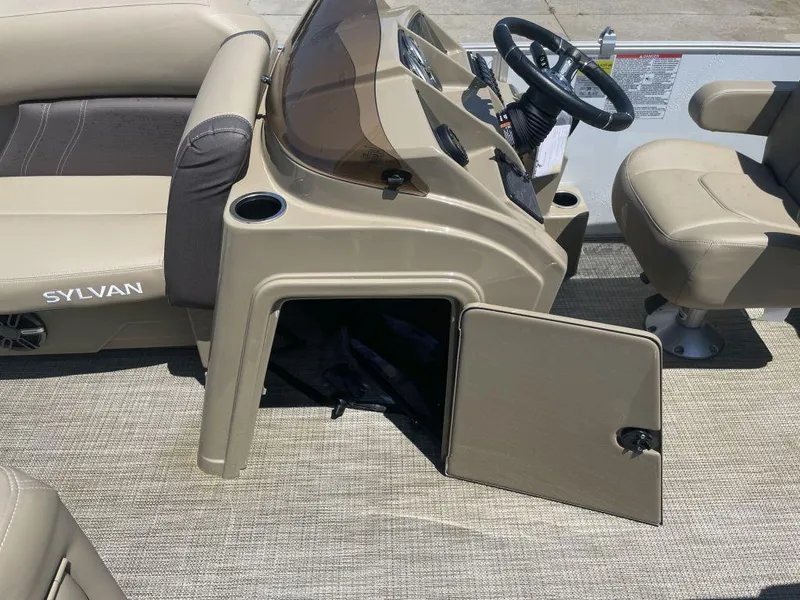 Slide: The Image of 2024 Sylvan 822 LZ Mirage boat interior with open storage compartment and steering console. - 18