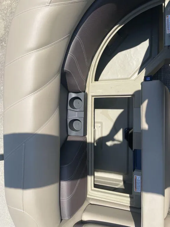 Slide: The Image of 2024 Sylvan 822 LZ Mirage boat interior with beige seating and cup holders. - 19