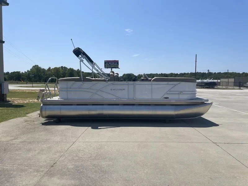 Slide: The Image of 2024 Sylvan 822 LZ Mirage pontoon boat parked on concrete under clear blue sky. - 3