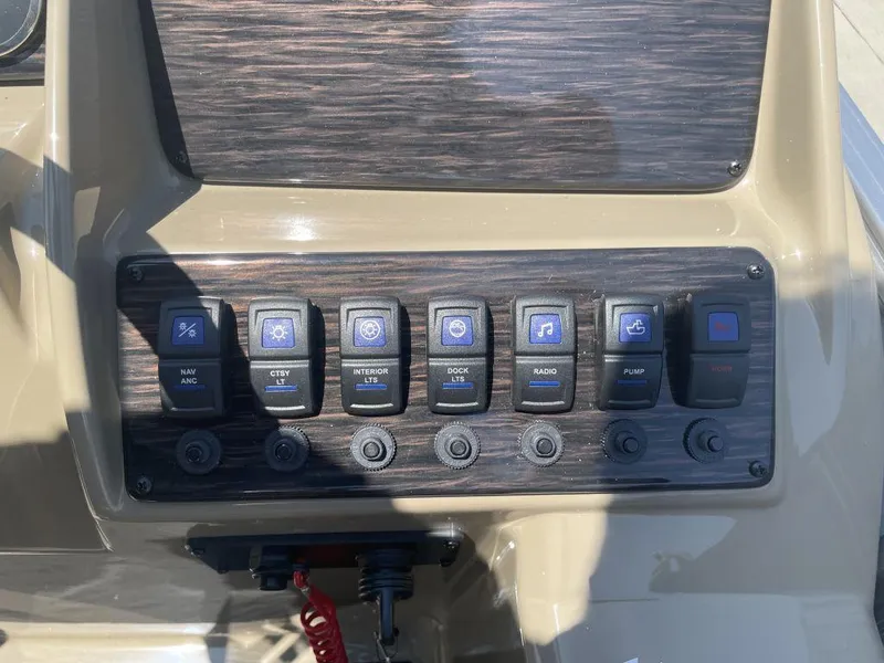 Slide: The Image of Control panel of 2024 Sylvan 822 LZ Mirage boat with various switches. - 9