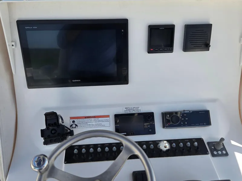 Slide: The Image of 2016 Contender 32 ST boat dashboard with Garmin electronics and control panel. - 17