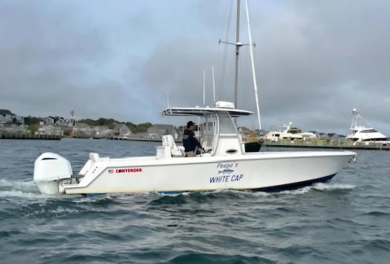 Slide: The Image of 2016 Contender 32 ST boat cruising on water near a harbor. - 2