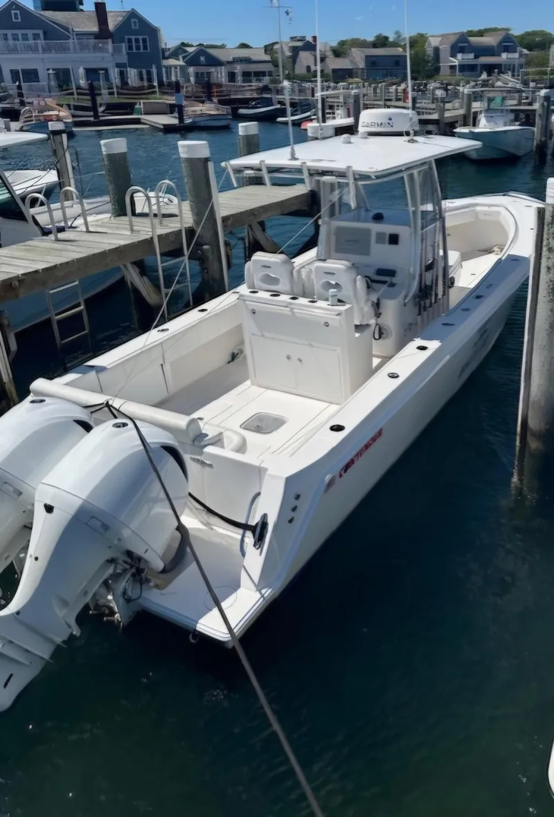 Slide: The Image of 2016 Contender 32 ST boat docked at marina, featuring dual outboard engines. - 6