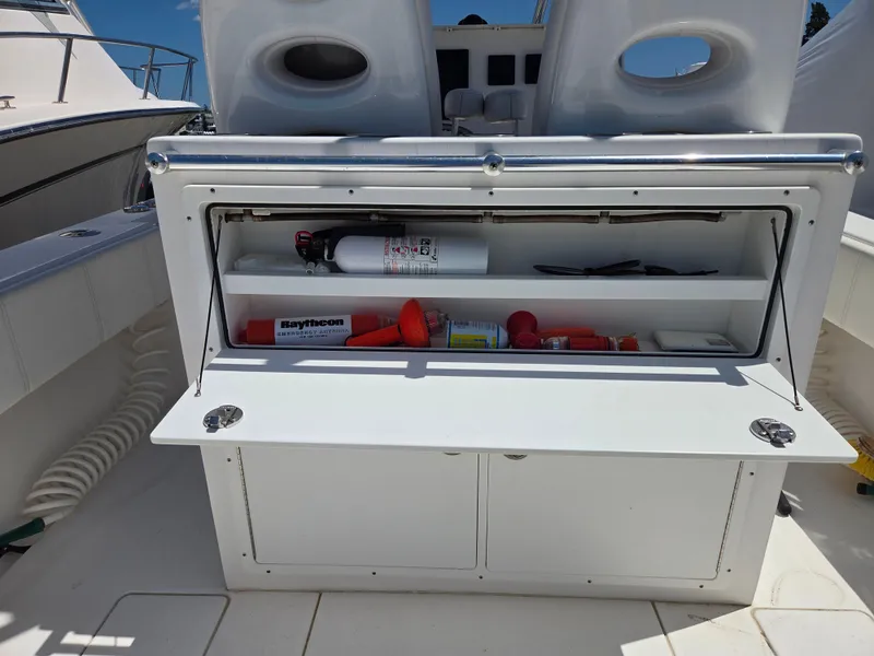 Slide: The Image of 2016 Contender 32 ST boat storage compartment with safety equipment and fire extinguisher. - 7