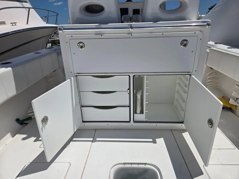 Slide: The Image of 2016 Contender 32 ST boat storage compartments with open doors and drawers. - 9