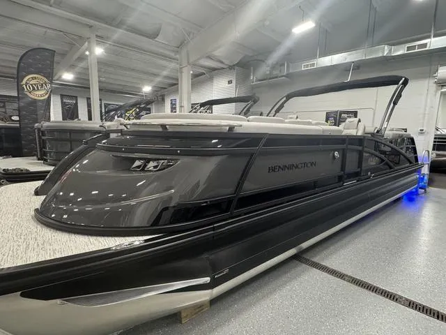 Slide: The Image of 2025 Bennington Q Quad Bench 25 QFB pontoon boat in showroom, sleek design, black finish. - 11
