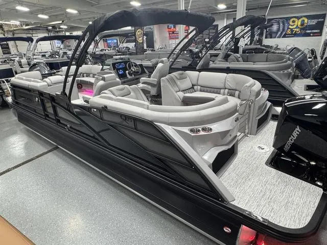Slide: The Image of 2025 Bennington Q Quad Bench 25 QFB pontoon boat in showroom, featuring luxurious seating and modern design. - 13