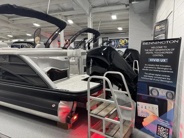 Slide: The Image of 2025 Bennington Q Quad Bench 25 QFB boat displayed indoors with digital touchscreen control sign. - 31