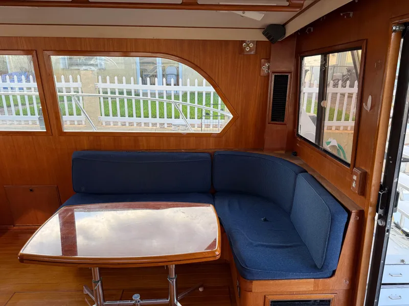 Slide: The Image of Interior of 1988 Hi-Star 44 Convertible yacht with blue seating and wooden table. - 11