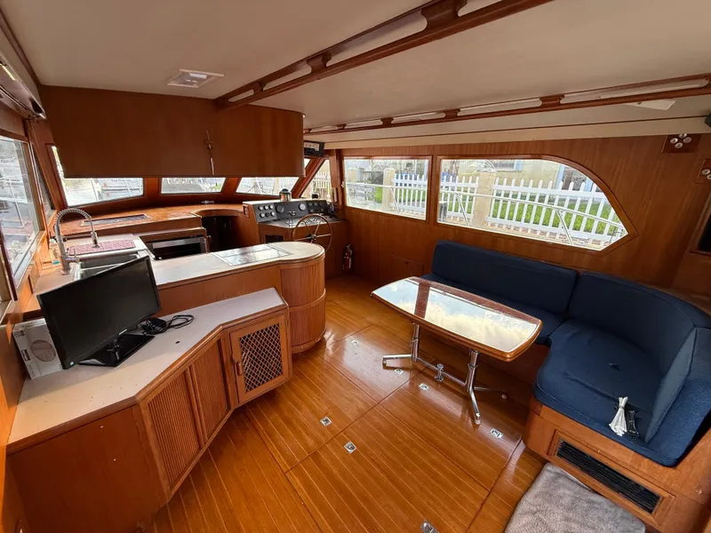 Slide: The Image of 1988 Hi-Star 44 Convertible yacht interior with wood finish, seating area, and helm station. - 12