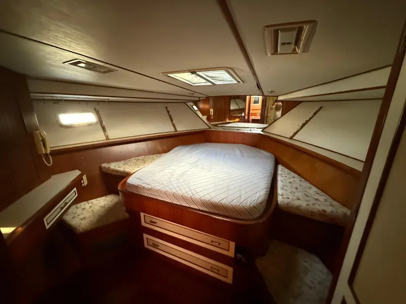 Slide: The Image of 1988 Hi-Star 44 Convertible yacht cabin with bed, wood paneling, and storage drawers. - 14