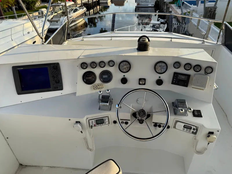 Slide: The Image of 1988 Hi-Star 44 Convertible yacht helm with gauges, steering wheel, and navigation equipment. - 4