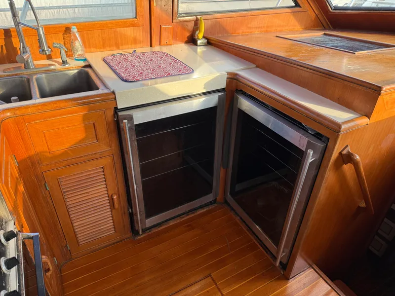 Slide: The Image of 1988 Hi-Star 44 Convertible yacht kitchen with dual fridges, sink, and wooden cabinetry. - 9