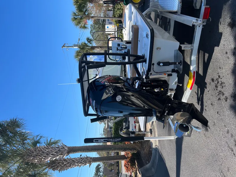 Slide: The Image of 2022 Xplor X7 boat on trailer with outboard motor, parked under clear blue sky. - 11