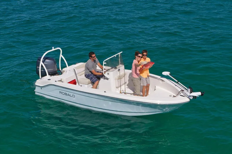 Slide: The Image of 2025 Robalo R160 Center Console boat on clear blue water with passengers. - 15