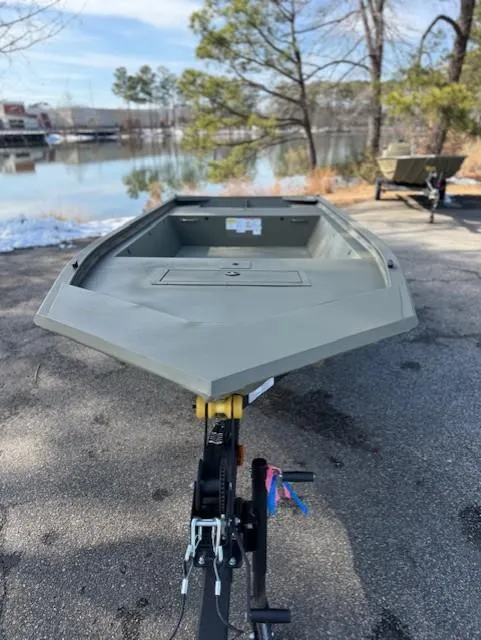 Slide: The Image of 2025 Tracker Grizzly 1648 Jon boat on trailer by a scenic lake. - 15