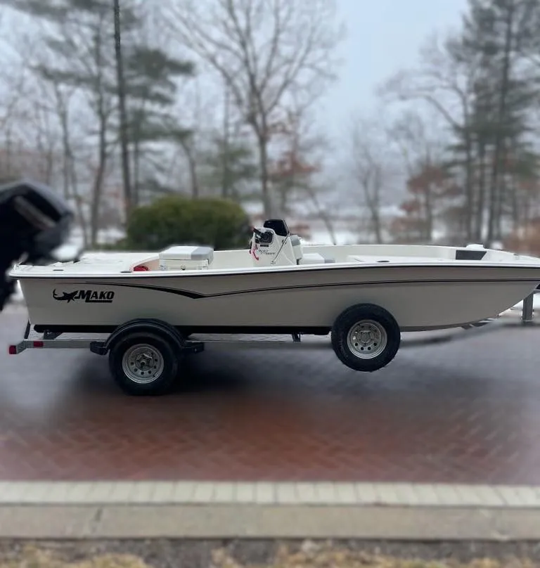 Slide: The Image of 2025 Mako Pro Skiff 17 CC boat on trailer, parked outdoors. - 2
