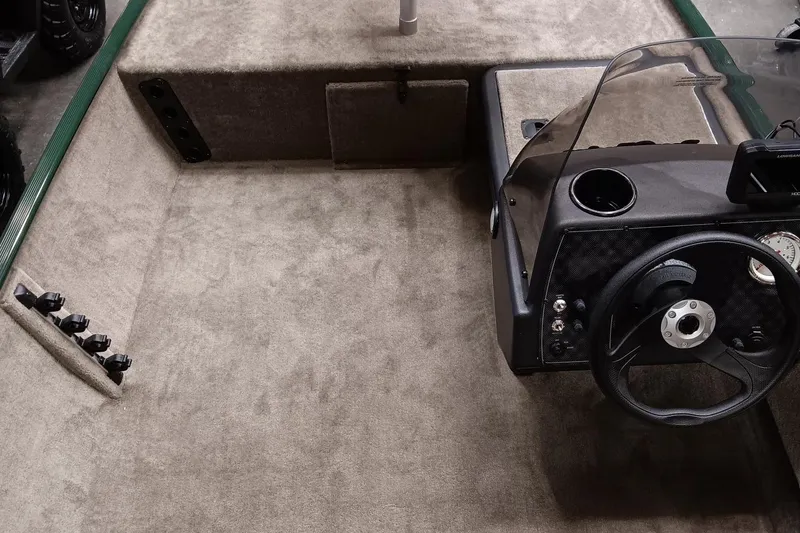 Slide: The Image of 2025 Tracker Bass Tracker Classic Limited boat interior with steering wheel and carpeted deck. - 5