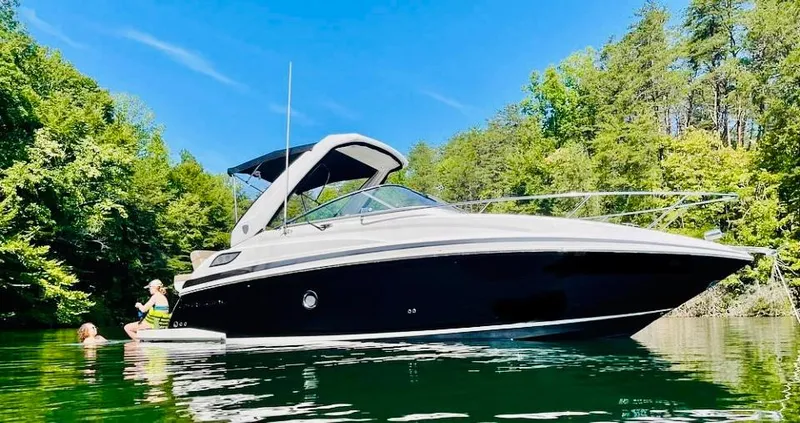 Slide: The Image of 2014 Regal 28 Express boat on a serene lake with lush green trees. - 0