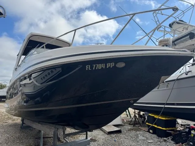 Slide: The Image of 2014 Regal 28 Express boat on dry dock under a partly cloudy sky. - 1