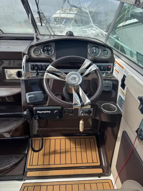 Slide: The Image of 2014 Regal 28 Express boat helm with steering wheel and control panel. - 13