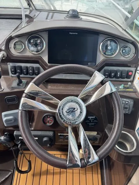 Slide: The Image of 2014 Regal 28 Express boat dashboard with steering wheel and control panel. - 14