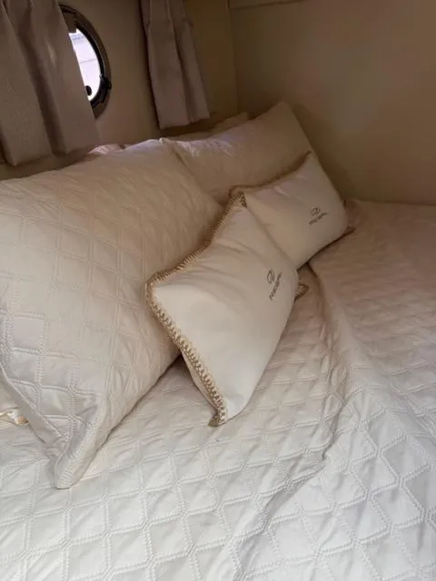 Slide: The Image of Luxurious cabin bedding inside a 2014 Regal 28 Express boat, featuring elegant white pillows. - 22