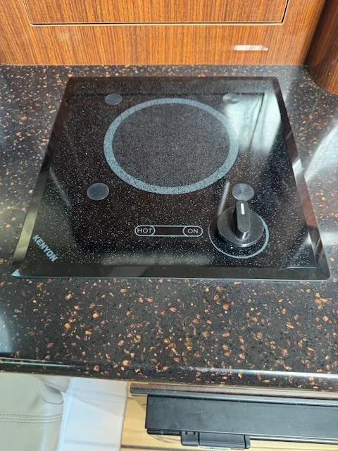 Slide: The Image of Kenyon stove on Regal 28 Express 2014 boat, set in a speckled countertop. - 23
