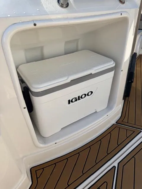 Slide: The Image of 2014 Regal 28 Express boat with Igloo cooler in storage compartment. - 31