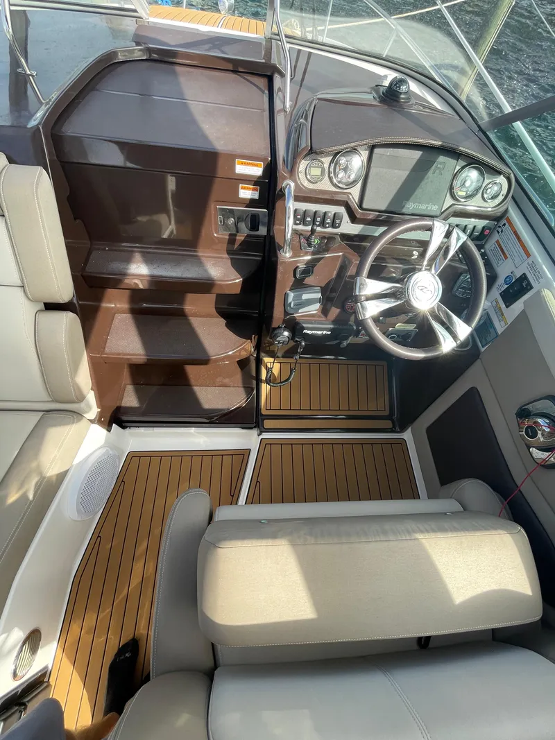 Slide: The Image of 2014 Regal 28 Express boat cockpit with modern steering and wood accents. - 5